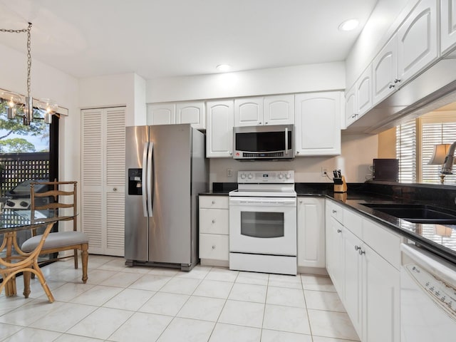 kitchen featuring plenty of natural light, an inviting chandelier, white cabinetry, and appliances with stainless steel finishes