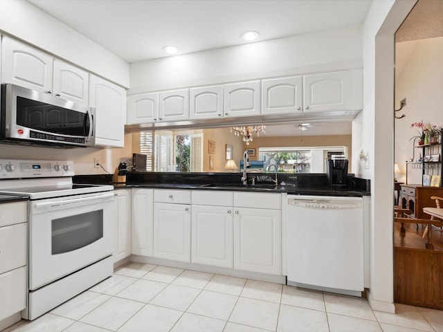 kitchen featuring white cabinets, a wealth of natural light, white appliances, and sink