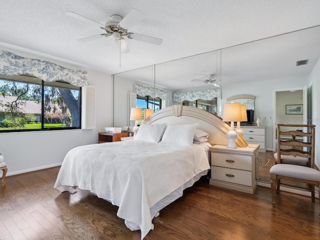 bedroom featuring a textured ceiling, ceiling fan, and dark hardwood / wood-style flooring