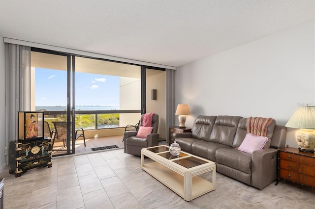 living room featuring floor to ceiling windows, a textured ceiling, and light tile flooring