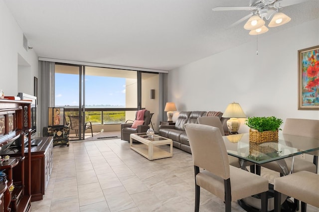 tiled dining room with floor to ceiling windows and ceiling fan