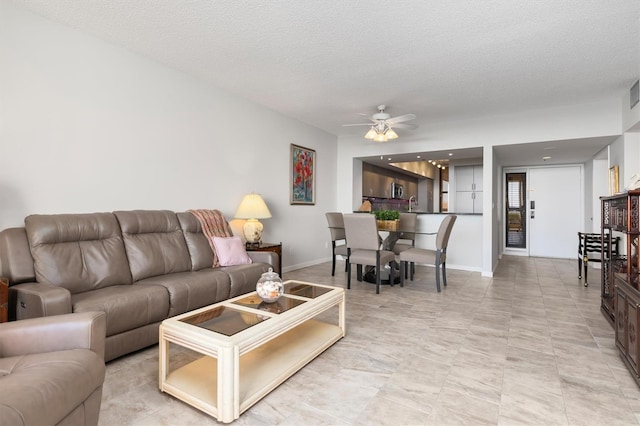 tiled living room featuring a textured ceiling and ceiling fan