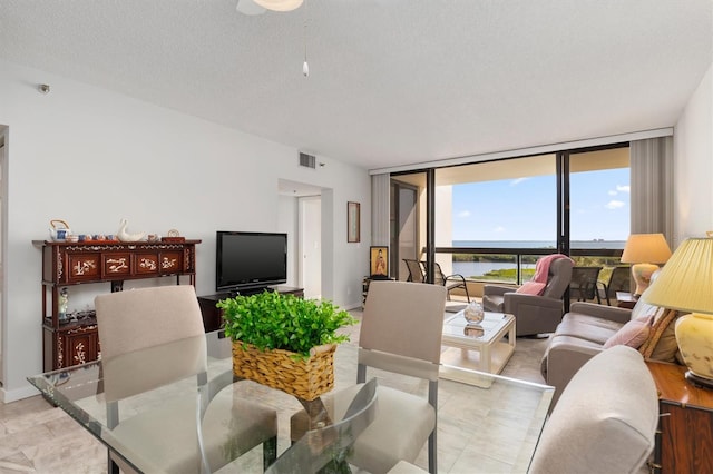 tiled living room with a wall of windows and a textured ceiling