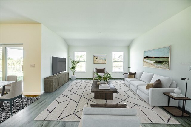 living room featuring lofted ceiling, a wealth of natural light, and light hardwood / wood-style flooring