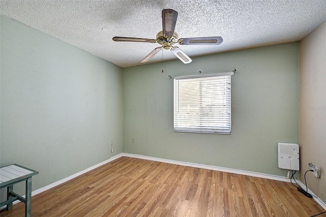 unfurnished room with ceiling fan, light hardwood / wood-style flooring, and a textured ceiling