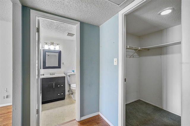 bathroom featuring vanity, toilet, and a textured ceiling