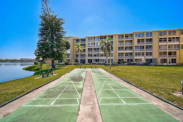 view of property's community featuring a lawn and a water view