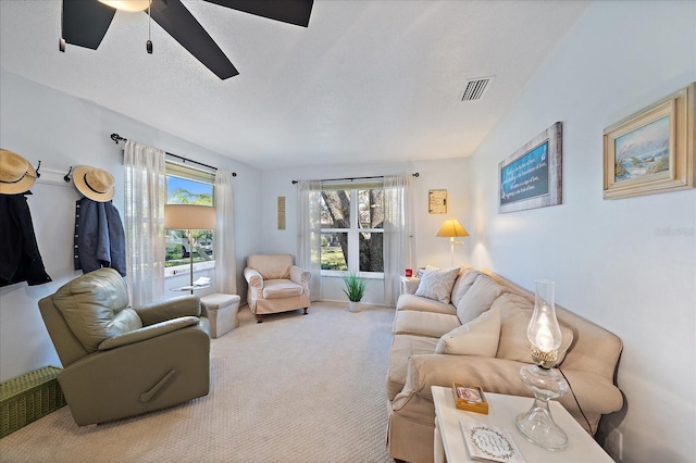 living room featuring carpet flooring, a textured ceiling, and ceiling fan