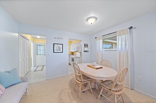 carpeted dining space with a textured ceiling