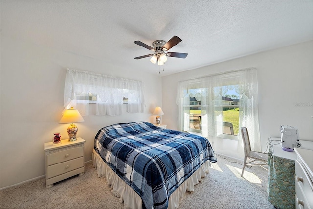 bedroom with a textured ceiling, ceiling fan, and light colored carpet