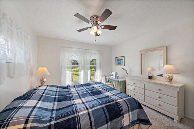 bedroom featuring ceiling fan, a textured ceiling, and carpet