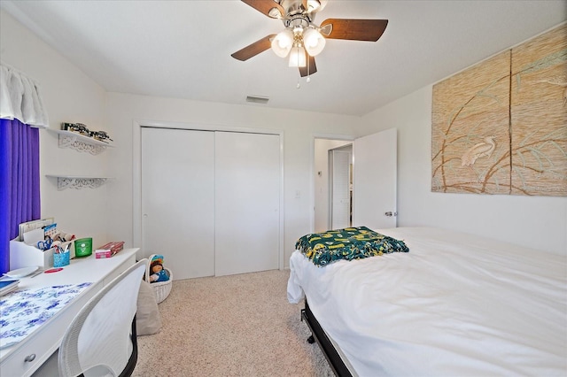 bedroom featuring ceiling fan, a closet, and light colored carpet