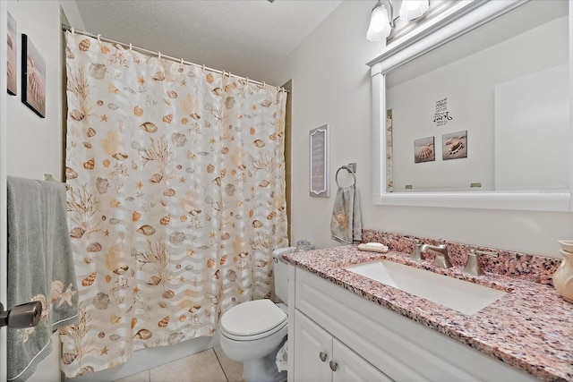 bathroom featuring a textured ceiling, tile floors, large vanity, and toilet