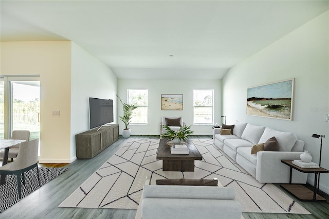 living room with vaulted ceiling, a wealth of natural light, and light wood-type flooring