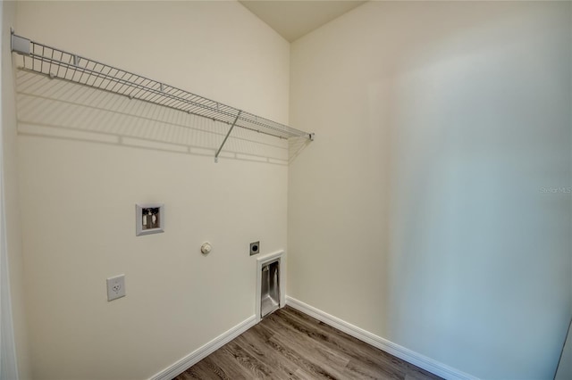 laundry area with wood-type flooring, hookup for an electric dryer, hookup for a washing machine, and hookup for a gas dryer