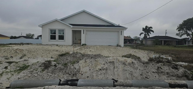 ranch-style house featuring an attached garage and stucco siding