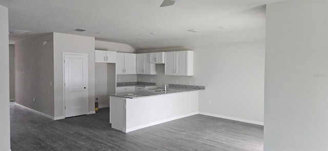 kitchen featuring white cabinetry, baseboards, dark wood-style flooring, and a sink