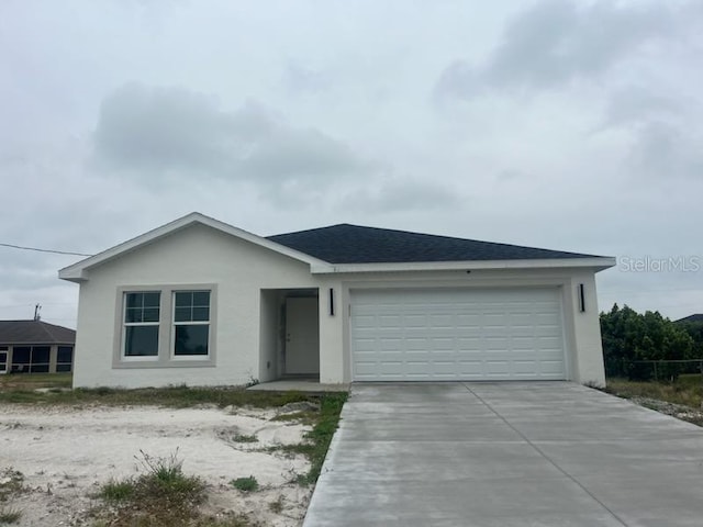 ranch-style house with stucco siding, roof with shingles, concrete driveway, and an attached garage