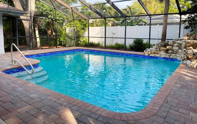 view of swimming pool with glass enclosure and a patio