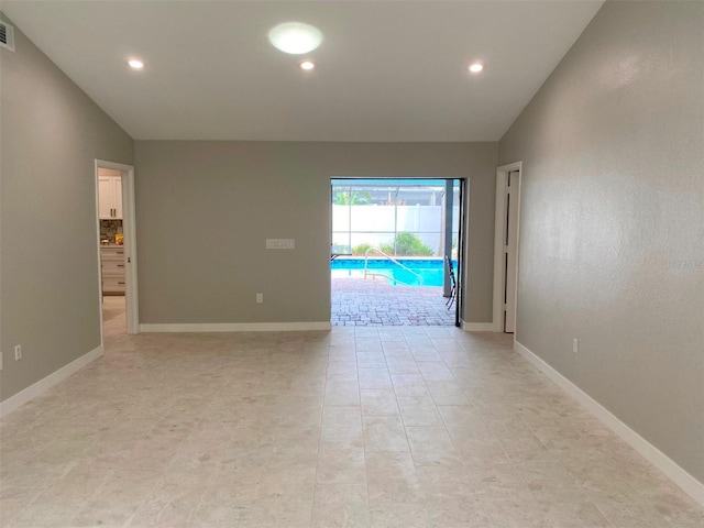 unfurnished room with vaulted ceiling