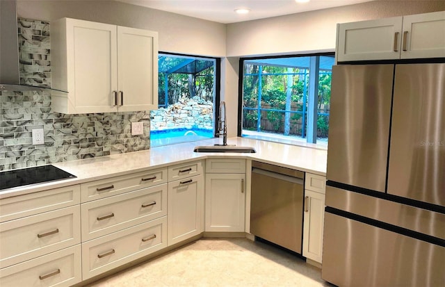 kitchen featuring white cabinets, appliances with stainless steel finishes, backsplash, and sink