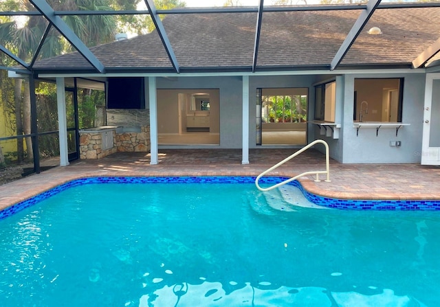 view of swimming pool with glass enclosure and a patio area