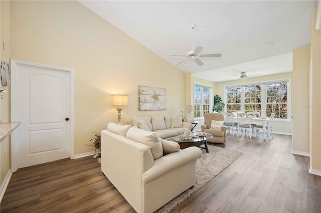 living room with high vaulted ceiling, ceiling fan, and dark wood-type flooring