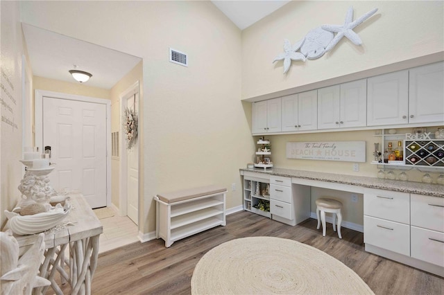 office area with built in desk and dark hardwood / wood-style floors