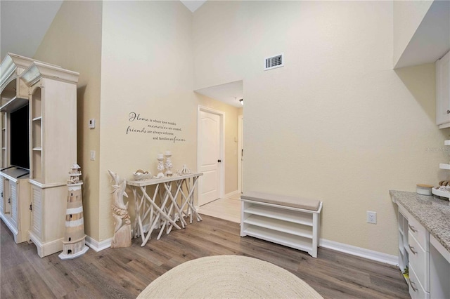 interior space with a high ceiling and hardwood / wood-style flooring