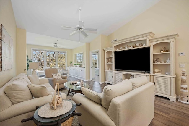 living room with ceiling fan, lofted ceiling, and hardwood / wood-style flooring