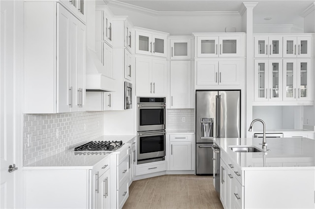 kitchen with crown molding, sink, stainless steel appliances, and white cabinets