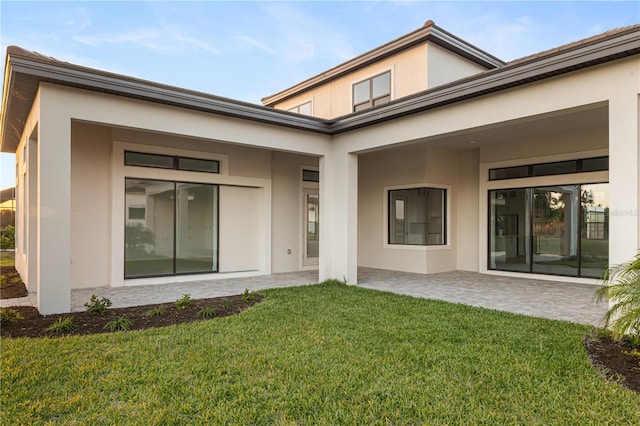 back of house with a lawn and a patio area