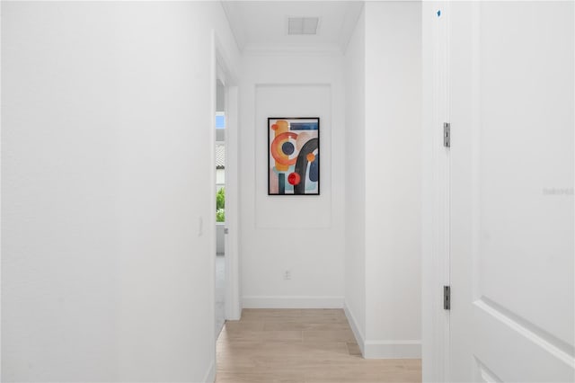 hall with light hardwood / wood-style flooring and ornamental molding