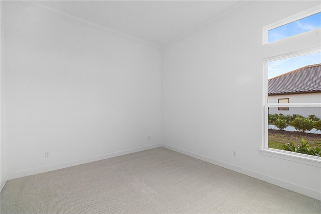 empty room with carpet floors, ornamental molding, and a healthy amount of sunlight