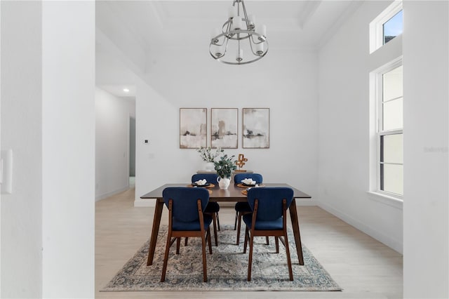 dining area with light hardwood / wood-style flooring, crown molding, and a chandelier