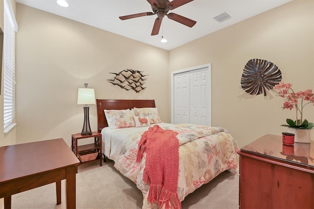 carpeted bedroom with ceiling fan and a closet