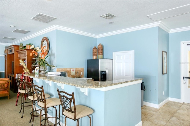 kitchen featuring stainless steel fridge with ice dispenser, ornamental molding, light tile floors, and light stone countertops