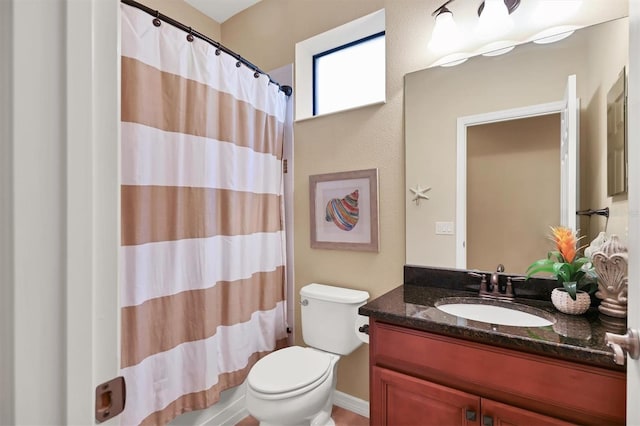 bathroom with toilet and vanity with extensive cabinet space