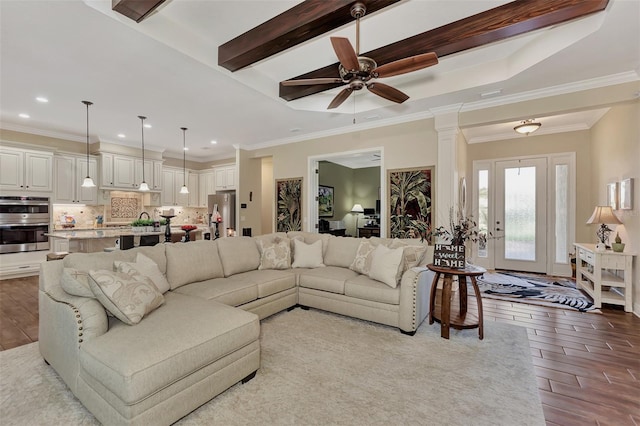 living room with light hardwood / wood-style floors, ornamental molding, ceiling fan, and ornate columns