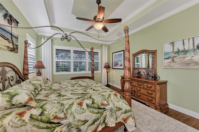 bedroom with a raised ceiling, dark hardwood / wood-style flooring, ceiling fan, and ornamental molding