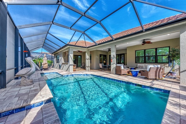 view of swimming pool with outdoor lounge area, a patio area, ceiling fan, and glass enclosure