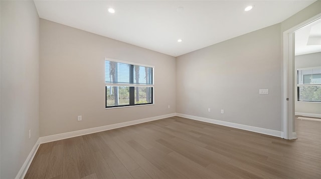 unfurnished room with a healthy amount of sunlight and hardwood / wood-style floors