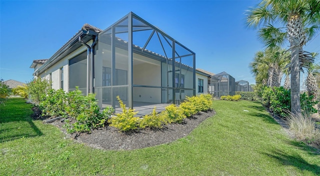 view of property exterior featuring a lawn, a patio, and a lanai