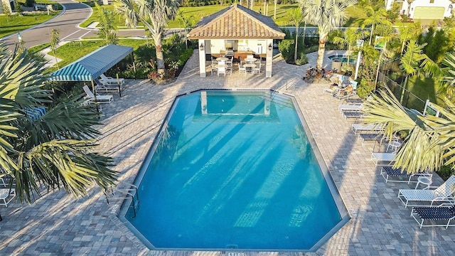 view of swimming pool featuring an outdoor bar and a patio area