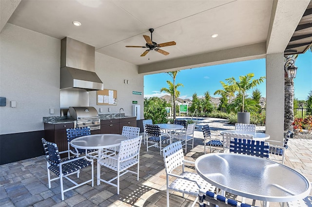 view of patio with ceiling fan, exterior kitchen, a grill, and sink