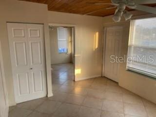 711A Pineland Ave, Venice, FL 34285 - spare room with ceiling fan, wood ceiling, light tile patterned floors, and plenty of natural light