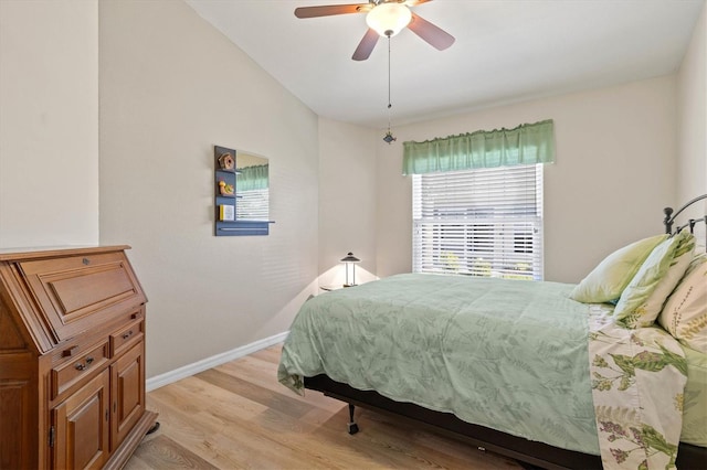 bedroom with baseboards, ceiling fan, and light wood finished floors