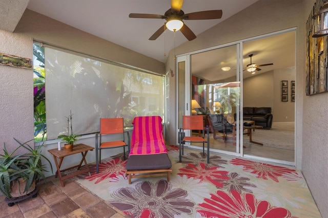 sunroom featuring lofted ceiling, ceiling fan, and plenty of natural light