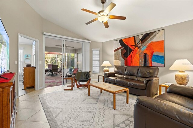 living room featuring light tile patterned floors, vaulted ceiling, a ceiling fan, and baseboards