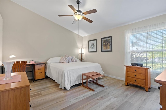 bedroom featuring lofted ceiling, baseboards, ceiling fan, and light wood finished floors